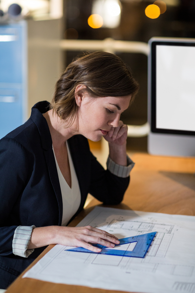 Businesswoman working on a blueprint in the office